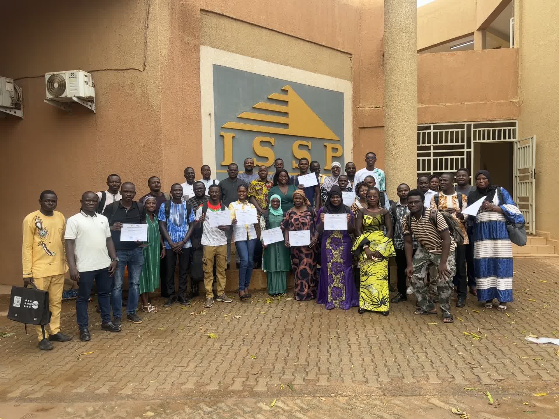 Participants et participantes réunis devant le bâtiment de l'ISSP, attestations à la main