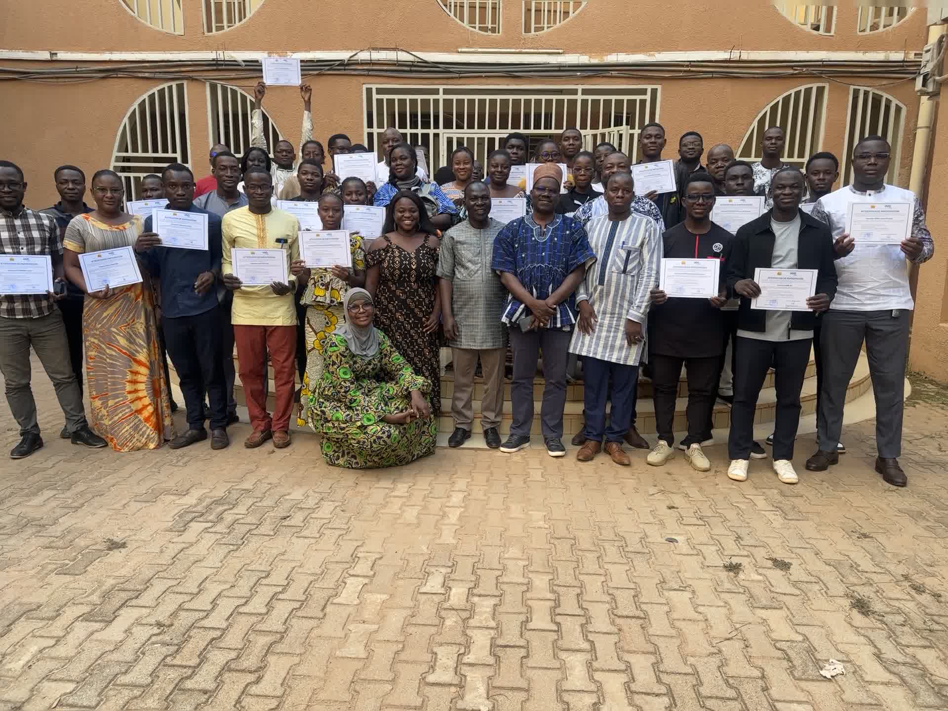 Participants et participantes présentant leur attestation de participation dans la cour de l'ISSP